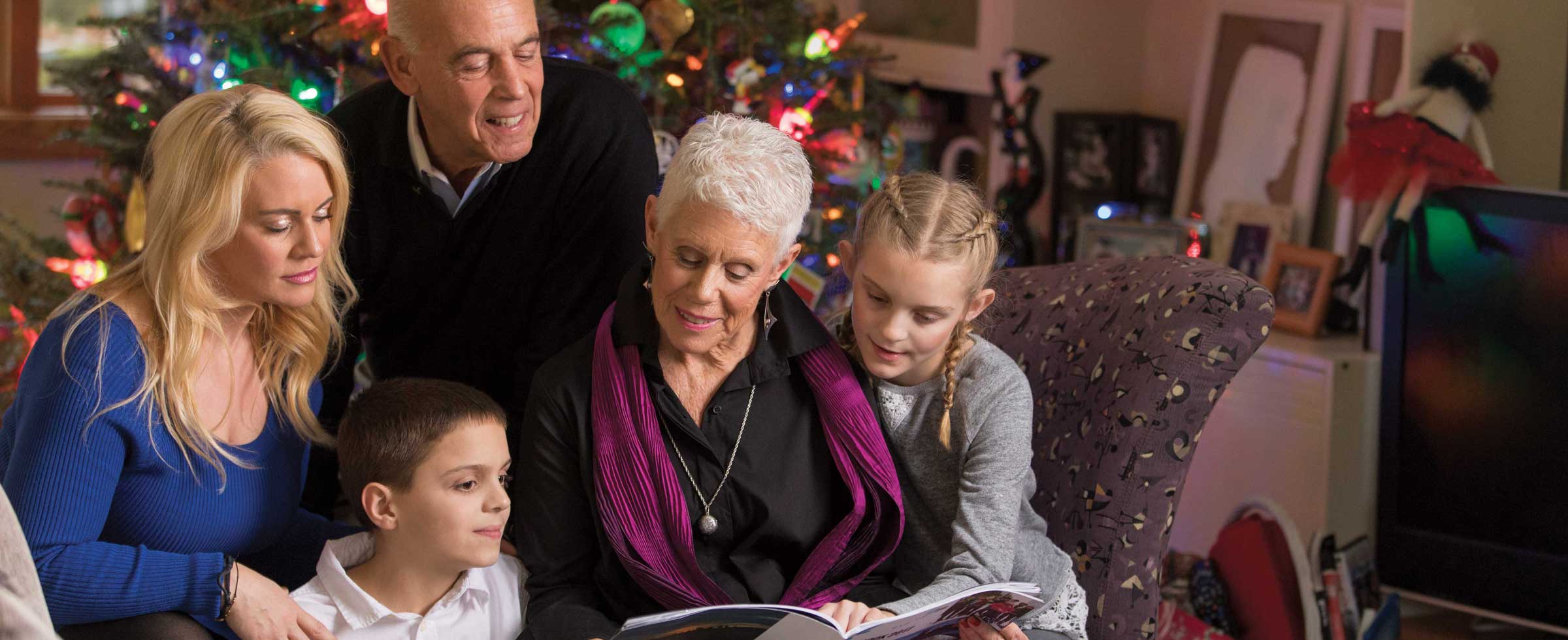 From left, Elizabeth Baun with her son, Julian; parents, John and Betsy Baun; and daughter, Ava, have made reviewing the Wish Book together a holiday tradition.