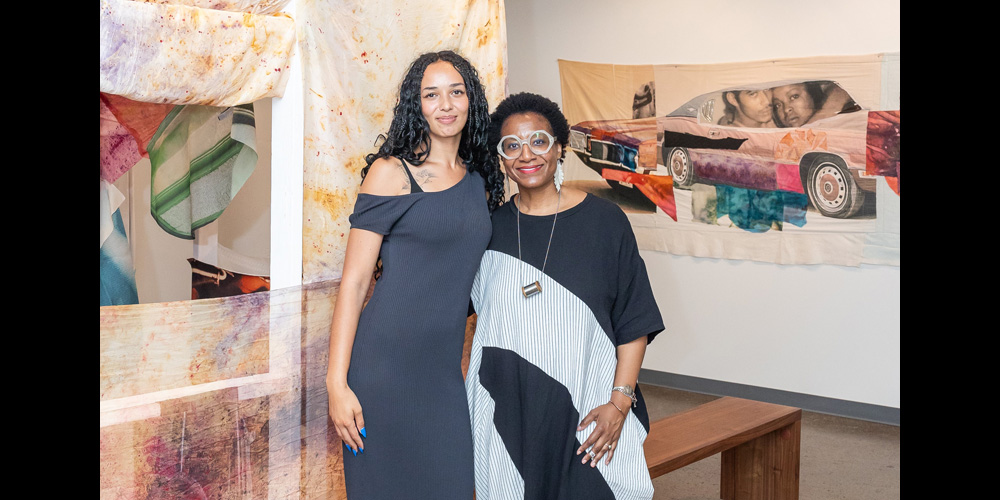 Artist Ambrose Rhapsody Murray pictured at their solo exhibition entitled, "My Memory is a Machine," with Kilolo Luckett, executive director and chief curator, Photo by Tara Geyer, Courtesy of ALMA | LEWIS.