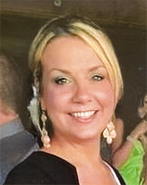 Smiling woman wearing a black shirt and dangling earrings. 