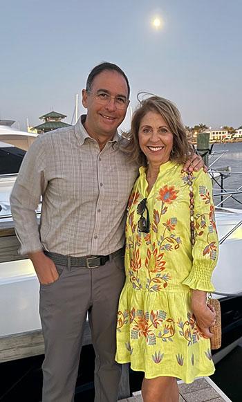 Chris and Theresa Farls standing on a dock in front of a boat.