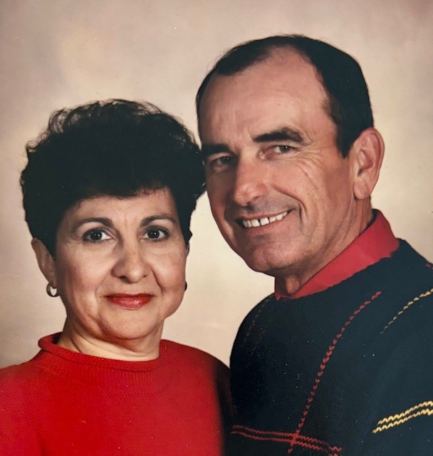 Woman with short, dark hair stands with smiling man with dark hair.