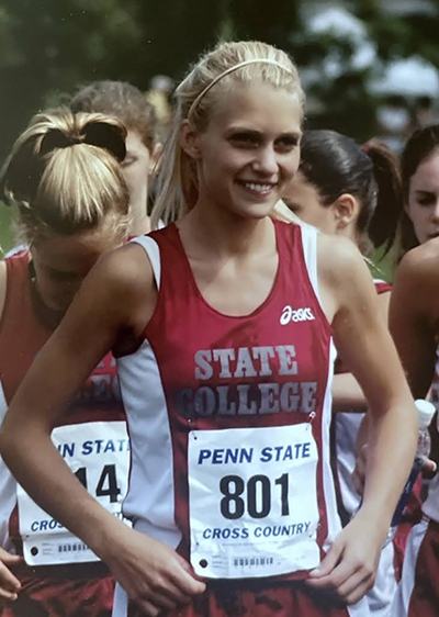 High school-aged girl with blond hair wearing track clothing.