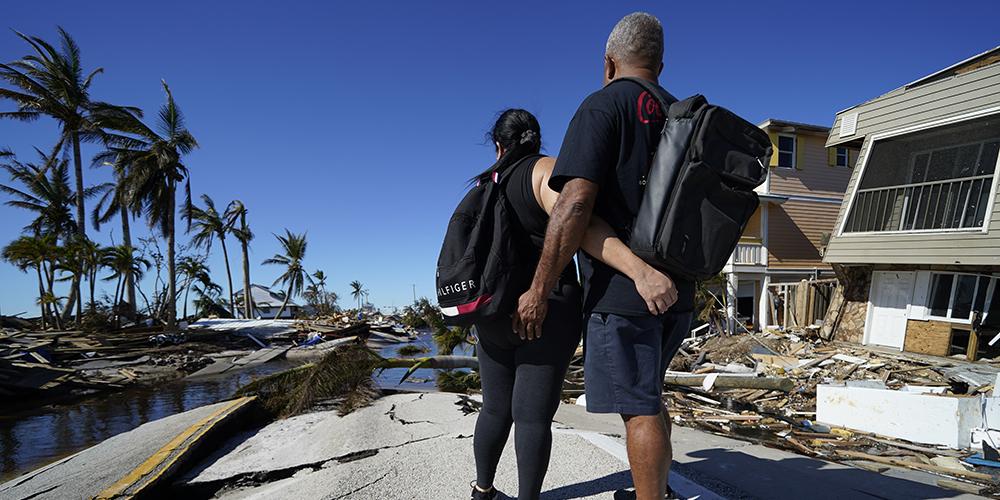 Lugo Elieser and his wife, Mara, who kept a boat docked nearby, look at the destroyed bridge leading to Pine Island, in the aftermath of Hurricane Ian in Spring Hill, Fla., Sunday, Oct. 2. The only bridge to the island is heavily damaged so it can only be reached by boat or air. (AP Photo: Gerald Herbert)