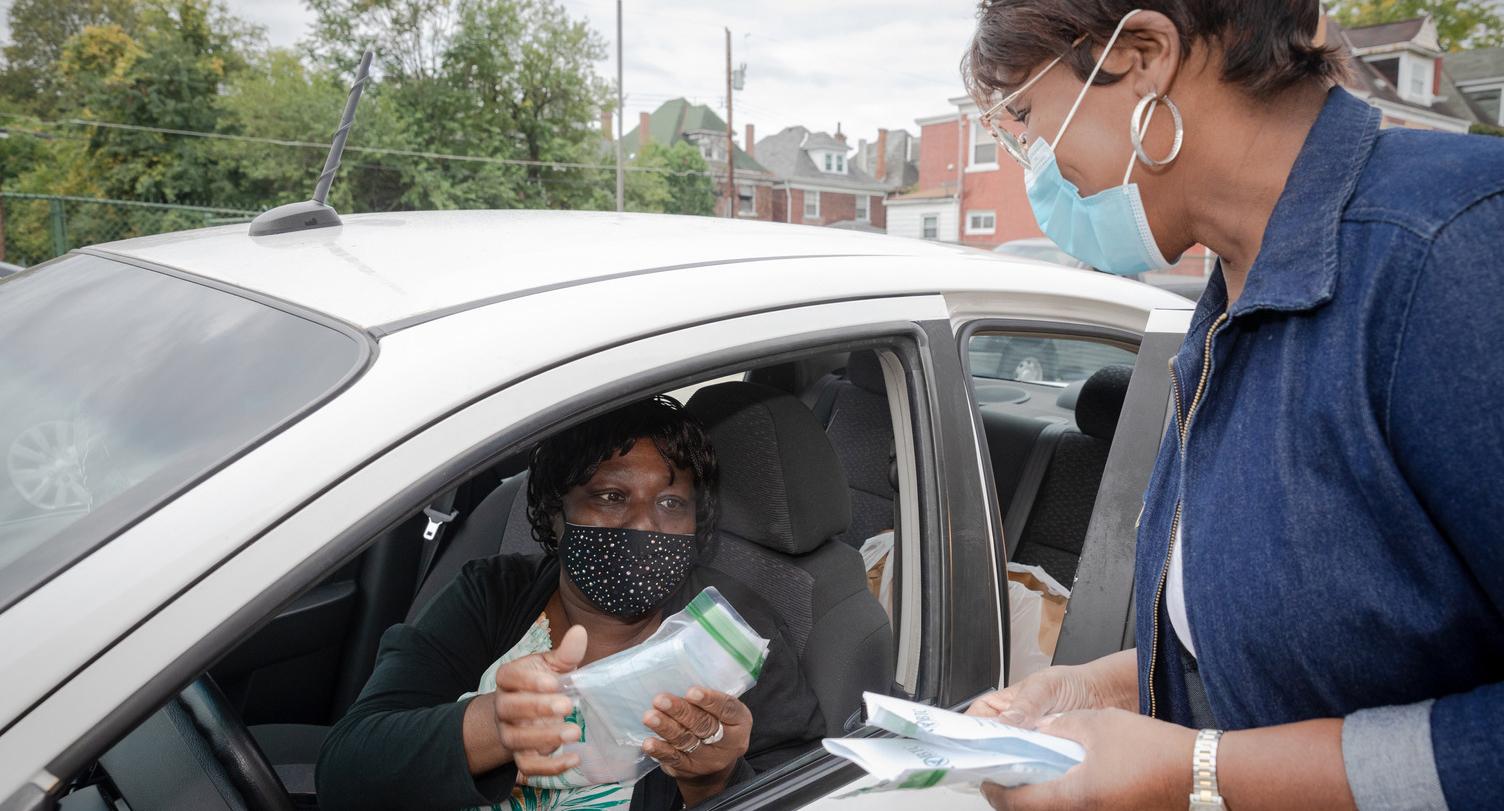 BTC Center Inc. a 2020 Small and Mighty grantee, provides a monthly food distribution. Guests also receive masks to help them stay safe in the pandemic. Monica Reese gives masks to Nadra Wright. Photo by Renee Rosensteel.