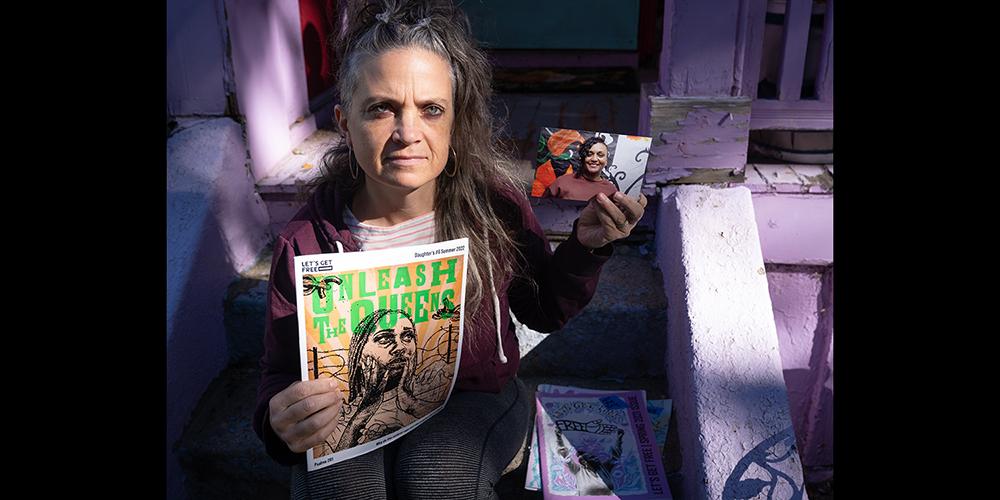 etta cetera holds a photo of co-editor Sarita Miller who is incarcerated. The Women and Trans Prisoner Defense Committee produces the magazine "Let's Get Free!" which is by and for women and transgender people who are incarcerated. (Photo credit: Renee Rosensteel.)